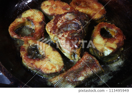 fried fish pieces on iron pan 113495949