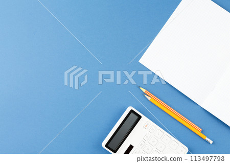 School notepad with study supplies on blue desk. 113497798