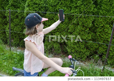 Portrait of a charming baby sitting in a stroller. little girl sitting in a stroller. baby walking in a stroller. child in summer outdoors. High quality photo Portrait of a charming baby sitting in a stroller. little girl sitting in a stroller. baby walking in a stroller. child in summer outdoors. High quality photo 113497837
