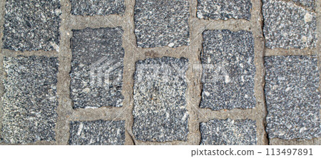 An old wall piled of gray stone blocks. An old wall piled of gray stone blocks. 113497891
