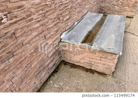 Basement opens in the building of house has window is located below ground level around facing brick. Window is covered with galvanized steel sheet to protect basement from precipitation during rain Basement opens in the building of house has window is located below ground level around facing brick. Window is covered with galvanized steel sheet to protect basement from precipitation during rain 113499174