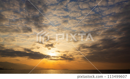 The setting sun and many clouds in the evening sky The setting sun and many clouds in the evening sky 113499607
