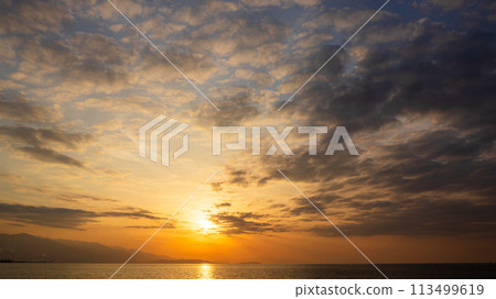 The setting sun and many clouds in the evening sky The setting sun and many clouds in the evening sky 113499619