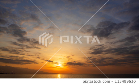 The setting sun and many clouds in the evening sky 113499630