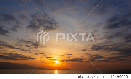 The setting sun and many clouds in the evening sky The setting sun and many clouds in the evening sky 113499633
