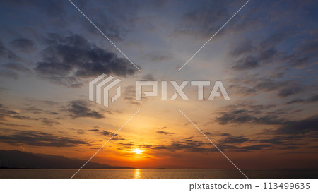 The setting sun and many clouds in the evening sky 113499635