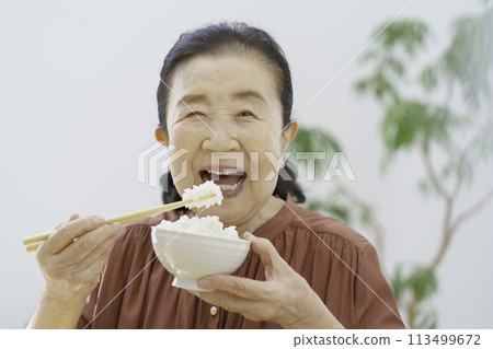 Senior woman eating rice Senior woman eating rice 113499672