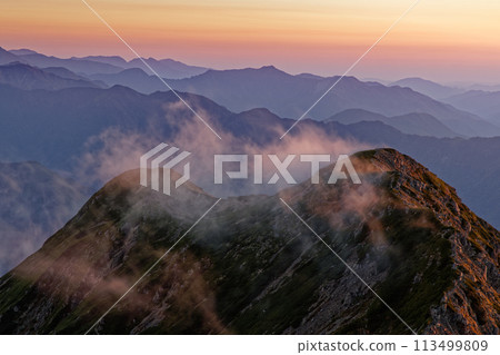 Mount Daisenjo in the evening sun, with clouds passing by as seen from Mount Senjo in the Southern Alps Mount Daisenjo in the evening sun, with clouds passing by as seen from Mount Senjo in the Southern Alps 113499809