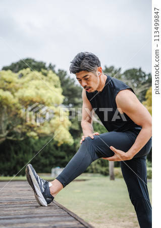 Man doing flexibility exercises outdoors 113499847