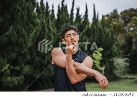 A man in his 40s doing warm-up exercises in the park 113500148