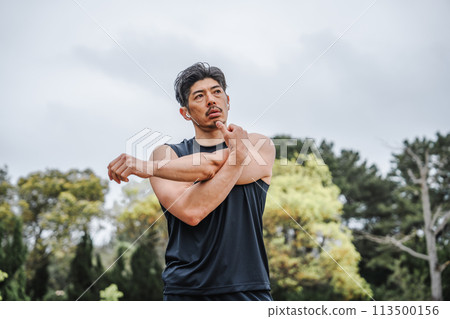 一名40多歲的男子在公園裡做熱身運動 113500156