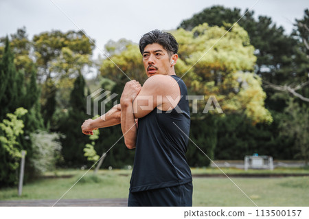 A man in his 40s doing warm-up exercises in the park A man in his 40s doing warm-up exercises in the park 113500157