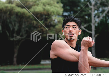 一名40多歲的男子在公園裡做熱身運動 113500158