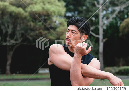 一名40多歲的男子在公園裡做熱身運動 一名40多歲的男子在公園裡做熱身運動 113500159