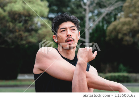 A man in his 40s doing warm-up exercises in the park 113500162