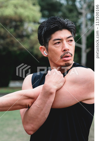 A man in his 40s doing warm-up exercises in the park 113500166