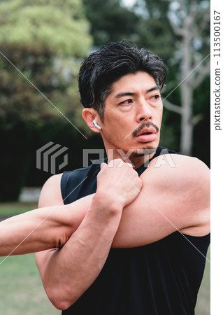 A man in his 40s doing warm-up exercises in the park A man in his 40s doing warm-up exercises in the park 113500167