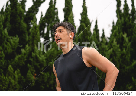 Man taking a break during training in the park Man taking a break during training in the park 113500424