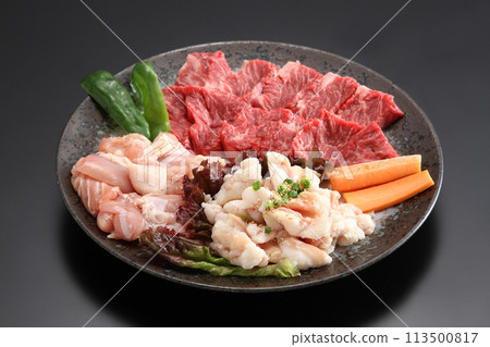 Assorted grilled meat ingredients - Premium grilled meat ingredients served on a black plate - Assorted beef, chicken and beef offal Assorted grilled meat ingredients - Premium grilled meat ingredients served on a black plate - Assorted beef, chicken and beef offal 113500817