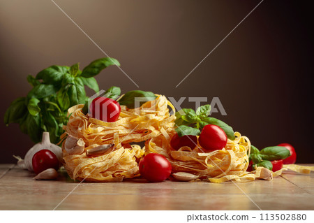 Homemade raw pasta with tomato, garlic, and basil. Homemade raw pasta with tomato, garlic, and basil. 113502880