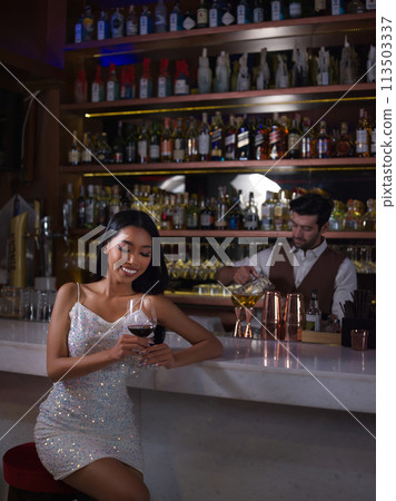 bartender making a wine glass for customer at a bar. at night club restaurant. bartender making a wine glass for customer at a bar. at night club restaurant. 113503337