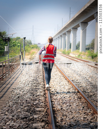 Engineer walking along the railway track .  113503356