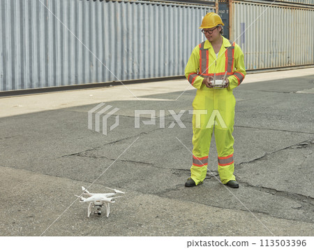 Engineer or worker piloting drone at ontainer cargo ship at shipping port. video surveillance Engineer or worker piloting drone at ontainer cargo ship at shipping port. video surveillance 113503396