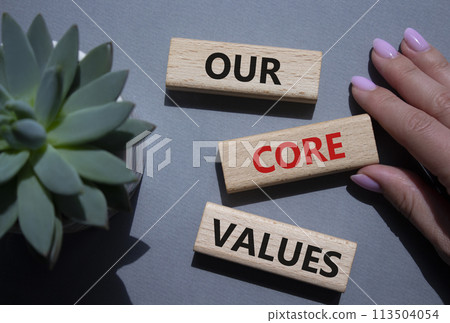 Our core values symbol. Concept words Our core values on wooden blocks. Beautiful grey background with succulent plant. Businessman hand. Business and Our core values concept. Copy space. Our core values symbol. Concept words Our core values on wooden blocks. Beautiful grey background with succulent plant. Businessman hand. Business and Our core values concept. Copy space. 113504054