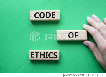Code of ethics symbol. Concept words Code of ethics on wooden blocks. Beautiful green background. Businessman hand. Business and Code of ethics concept. Copy space. Code of ethics symbol. Concept words Code of ethics on wooden blocks. Beautiful green background. Businessman hand. Business and Code of ethics concept. Copy space. 113504118