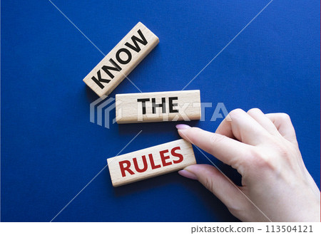 Know the rules symbol. Wooden blocks with words Know the rules. Beautiful deep blue background. Businessman hand. Business and Know the rules concept. Copy space. 113504121