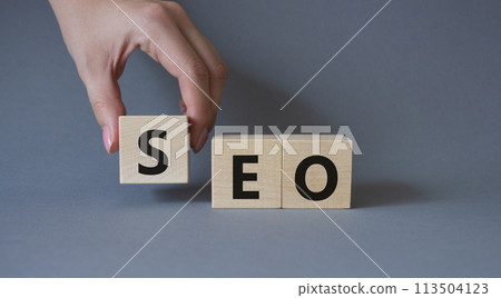 SEO - Search Engine Optimization symbol. Wooden blocks with words SEO. Businessman hand. Beautiful grey background. Business and SEO concept. Copy space. SEO - Search Engine Optimization symbol. Wooden blocks with words SEO. Businessman hand. Beautiful grey background. Business and SEO concept. Copy space. 113504123