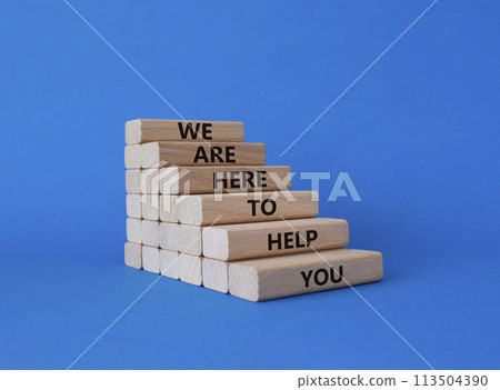 We are here to help you symbol. Concept words we are here to help you on wooden blocks. Beautiful blue background. Business and we are here to help you concept. Copy space. 113504390