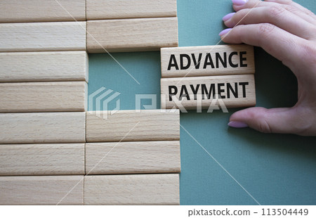 Advance Payment symbol. Concept words Advance Payment on wooden blocks. Businessman hand. Beautiful grey green background. Business and Advance Payment concept. Copy space Advance Payment symbol. Concept words Advance Payment on wooden blocks. Businessman hand. Beautiful grey green background. Business and Advance Payment concept. Copy space 113504449
