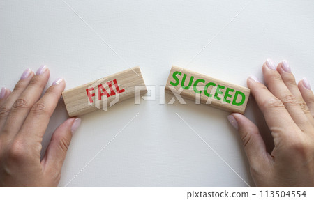 Fail or Succeed symbol. Concept word Fail or Succeed on wooden blocks. Businessman hand. Beautiful white background. Business and Fail or Succeed concept. Copy space 113504554