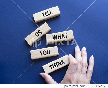 Tell us what you think symbol. Wooden blocks with words Tell us what you think. Beautiful deep blue background. Businessman hand. Business and Tell us what you think concept. Copy space. 113505257