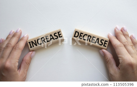 Increase or Decrease symbol. Concept word Increase or Decrease on wooden blocks. Businessman hand. Beautiful white background. Business and Increase or Decrease concept. Copy space 113505396