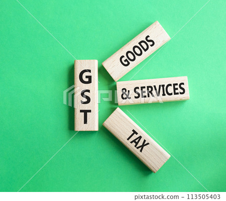 GST - Goods and Services Tax symbol. Concept word GST on wooden blocks. Beautiful green background. Business and GST concept. Copy space. 113505403