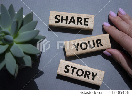 Share your story symbol. Wooden blocks with words Share your story. Beautiful grey background. Businessman hand. Business and Share your story concept. Copy space. 113505406