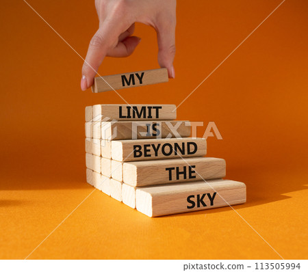 My limit is beyond the sky symbol. Wooden blocks with words My limit is beyond the sky. Beautiful orange background. Businessman hand. Business concept. Copy space. 113505994
