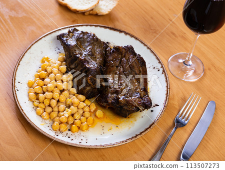 Roast whole pork knuckle served with chickpea on plate closeup Roast whole pork knuckle served with chickpea on plate closeup 113507273