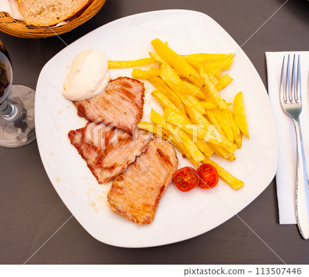 Tasty grilled pork meat with boiled potatoes served on table Tasty grilled pork meat with boiled potatoes served on table 113507446