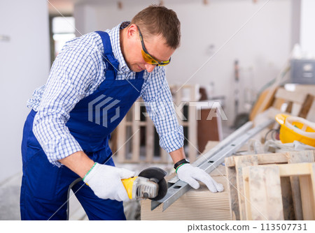 Focused man renovating home, cutting metal profile Focused man renovating home, cutting metal profile 113507731