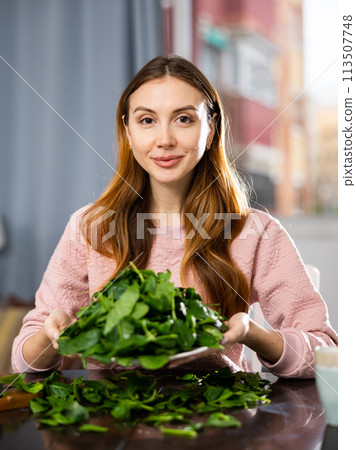 Portrait of a positive young woman with a plate of spinach Portrait of a positive young woman with a plate of spinach 113507748