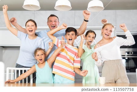 Big friendly family is rejoicing with happiness and raising their hands up they shout with happiness 113507758