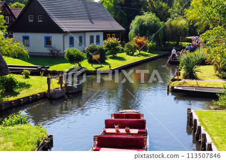 Scenic view of green riverside garden house german national park Spreewald on spring summer sunny day . Spree river forest greenery canal nature tranquil landscape in Germany blue sky background 113507846