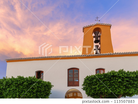Historic Santa Gertrude Church in Ibiza, orange tower and lush greenery at sunset Historic Santa Gertrude Church in Ibiza, orange tower and lush greenery at sunset 113507883