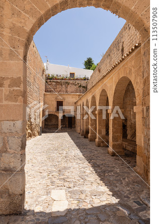 Sunlight dapples the cobbled courtyard of Almudaina Castle in Eivissa, inviting entry 113507908