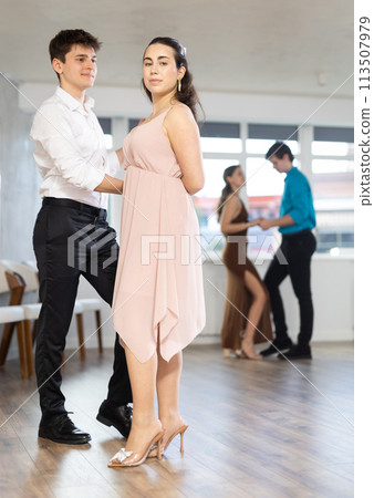 Hispanic guy practicing bachata with young brunette in dance class Hispanic guy practicing bachata with young brunette in dance class 113507979