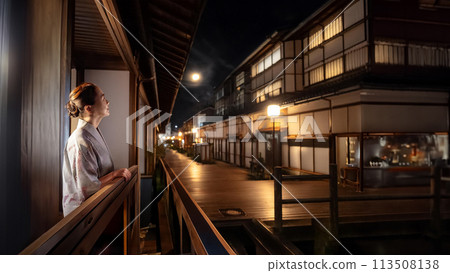 A senior woman looking at the night view of the inn district and the night sky 113508138