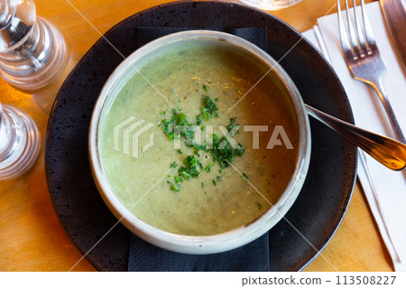 Healthy vegetable puree soup served with chopped fresh greens 113508227